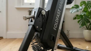 A detailed, photorealistic illustration focusing on the sturdy central folding mechanism and engineering of a FOLDFAST MAGNETIC rower with a visible 'UK DESIGNED' plate.