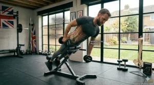 An illustration of a fitness enthusiast holding a bumper weight plate across their chest to progress a hyperextension bench routine.